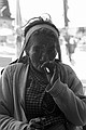 Old woman stops for a smoke and a stare.